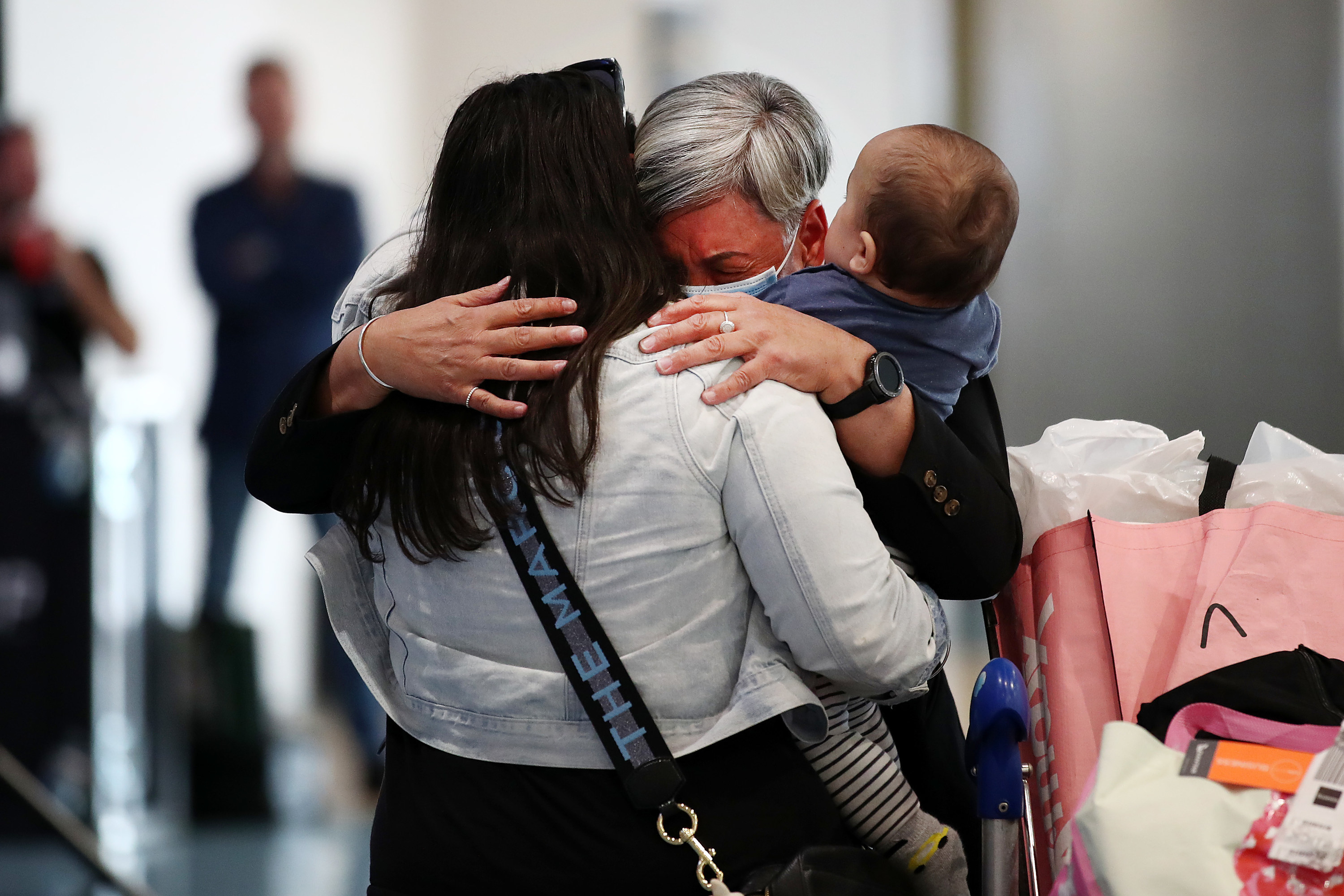 Two adults and a toddler embrace