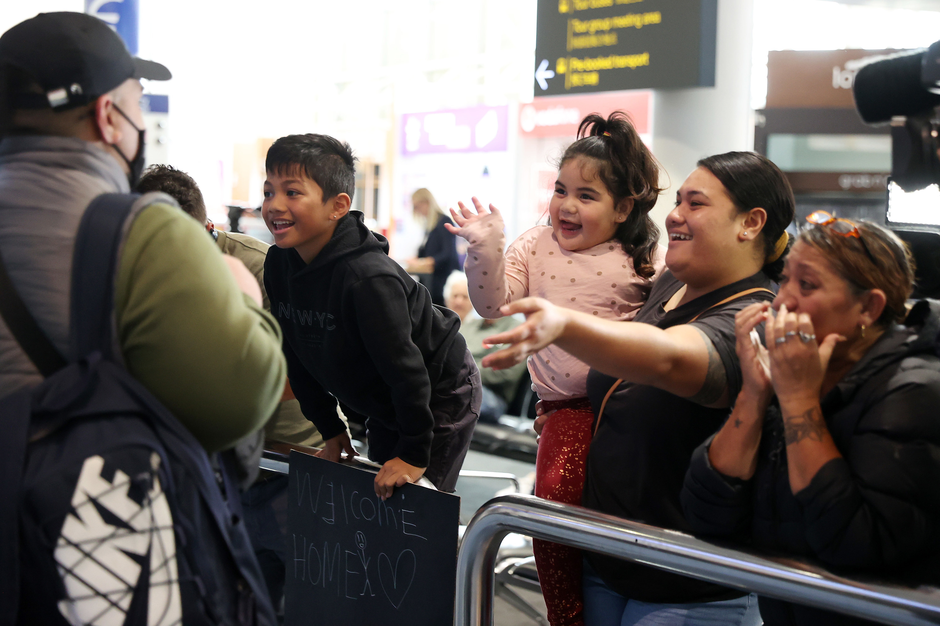 A family waves as they see someone arrive