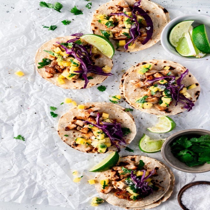 Huli huli chicken tacos with slaw, mango, and lime.