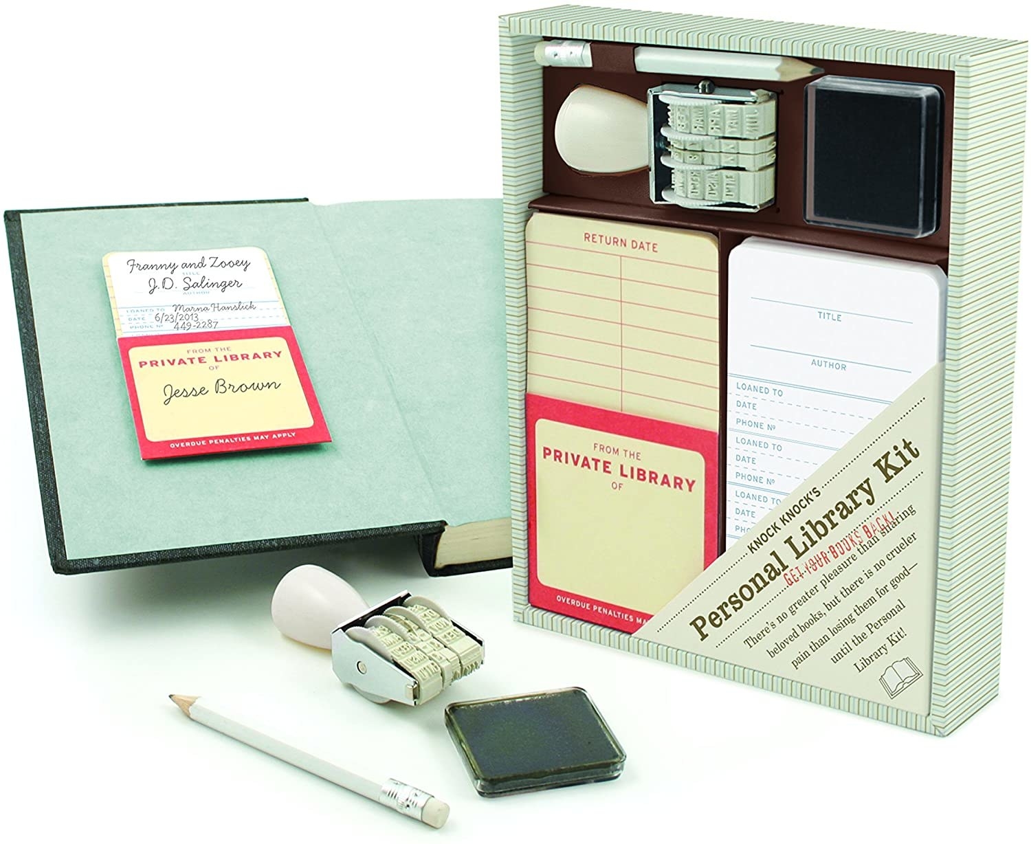 the kit sitting next to an open book with one of the pockets attached to the inside cover with a library card inside, a date stamp, and an ink pad