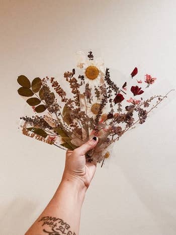 a hand holding a bunch of different floral bookmarks