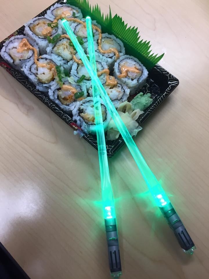 a reviewer&#x27;s photo of the green chopsticks used with sushi