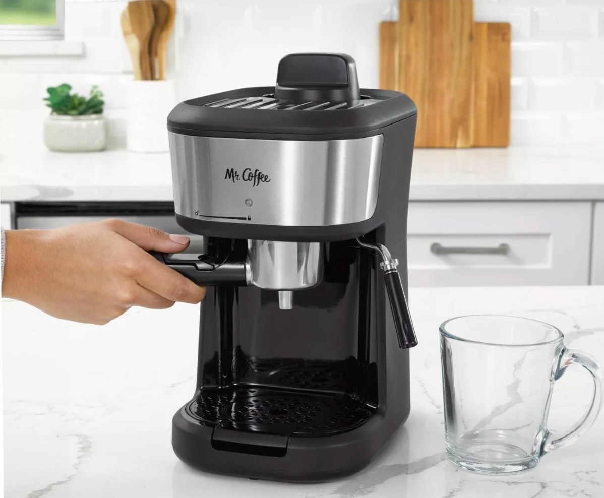 The Mr. Coffee 4-shot steam multi-coffee maker being used by a model