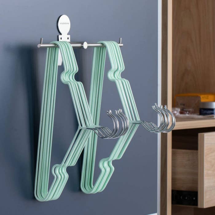 The rack on a wall with hangers on it