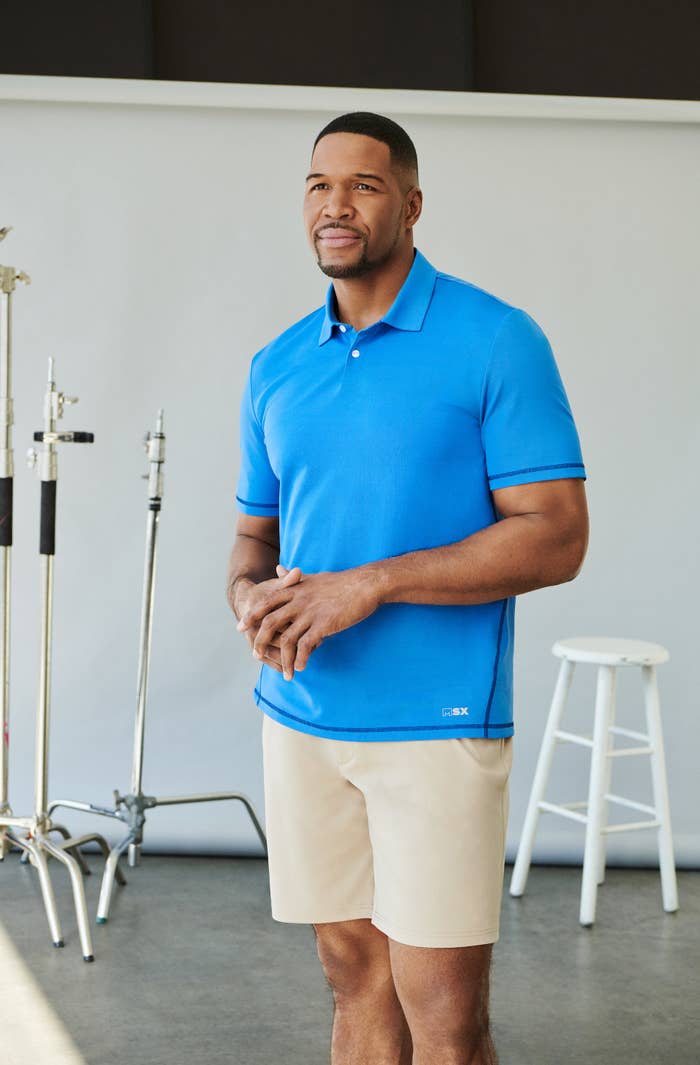 Michael Strahan wearing a blue polo shirt and shorts