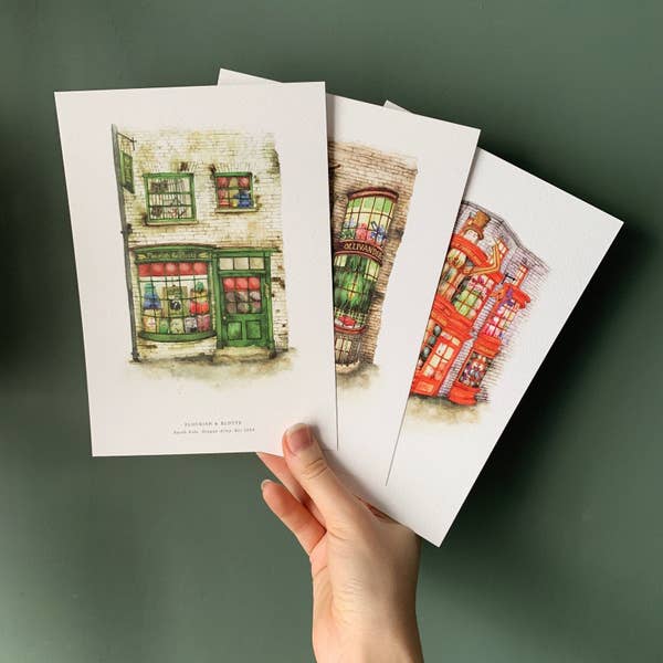 hand holding the three art prints