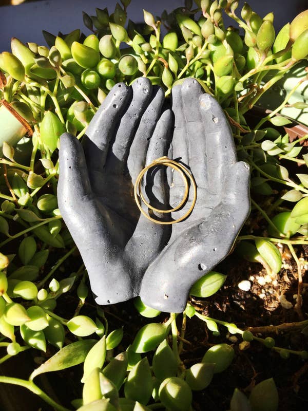 concrete hands holding earrings 