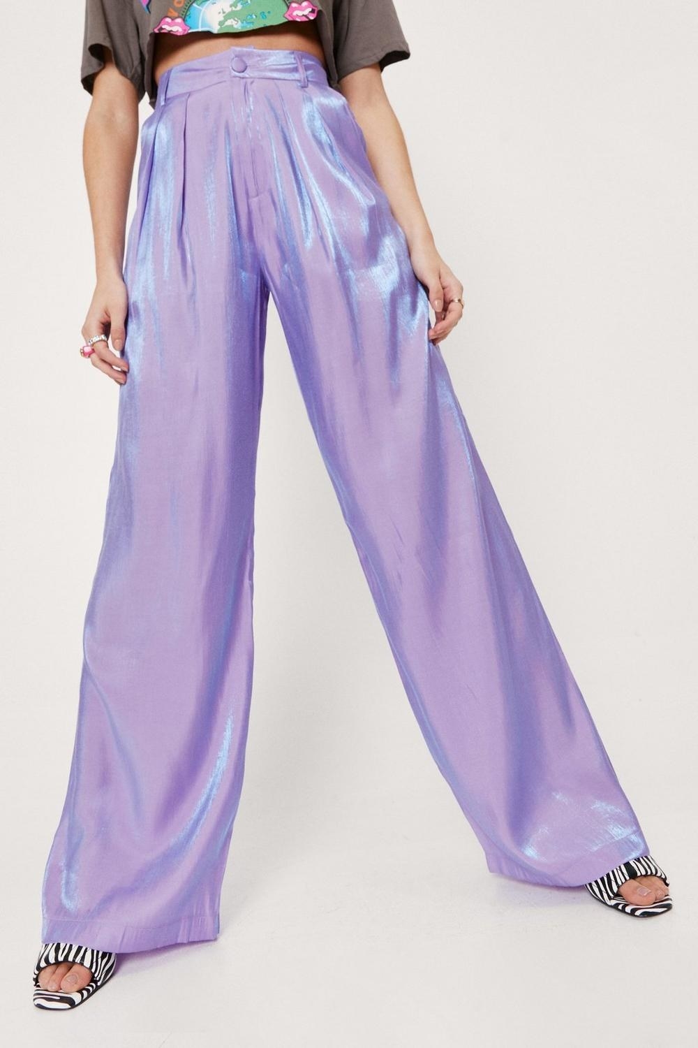 a person wearing a pair of wide legged metallic pants 