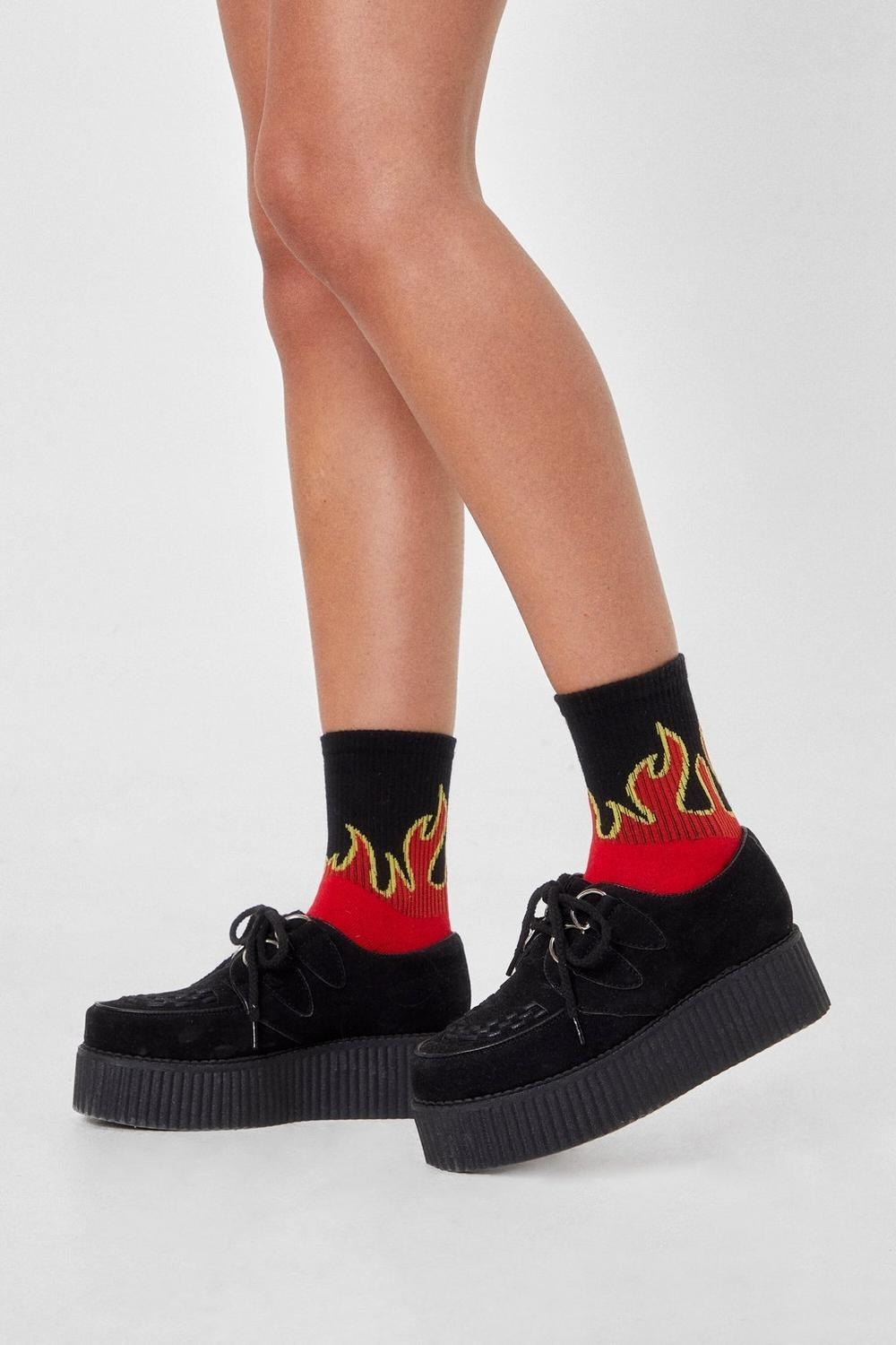 a person wearing socks with flames on them 