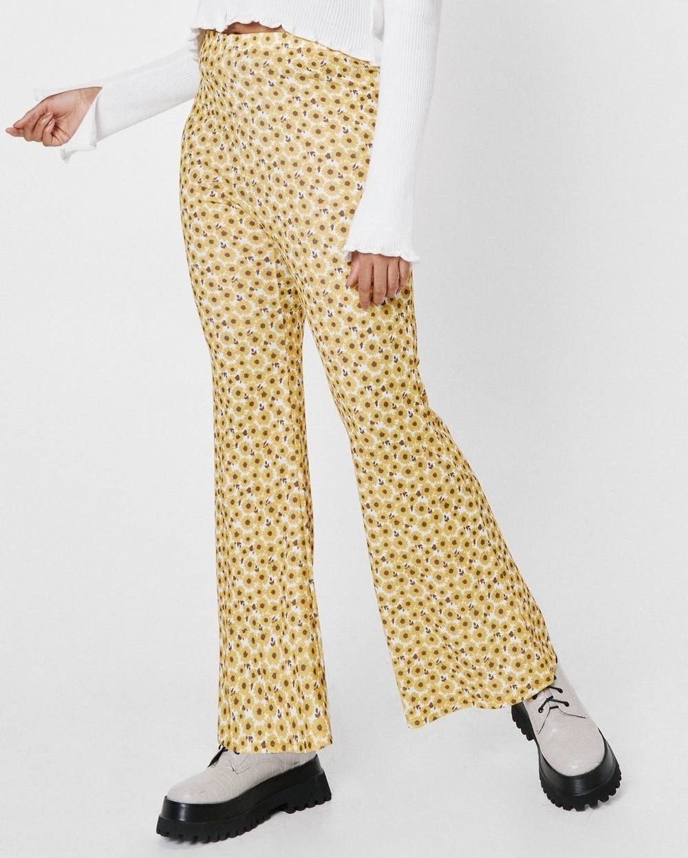a pair of pants that flare toward the bottom with daisies patterned all over 