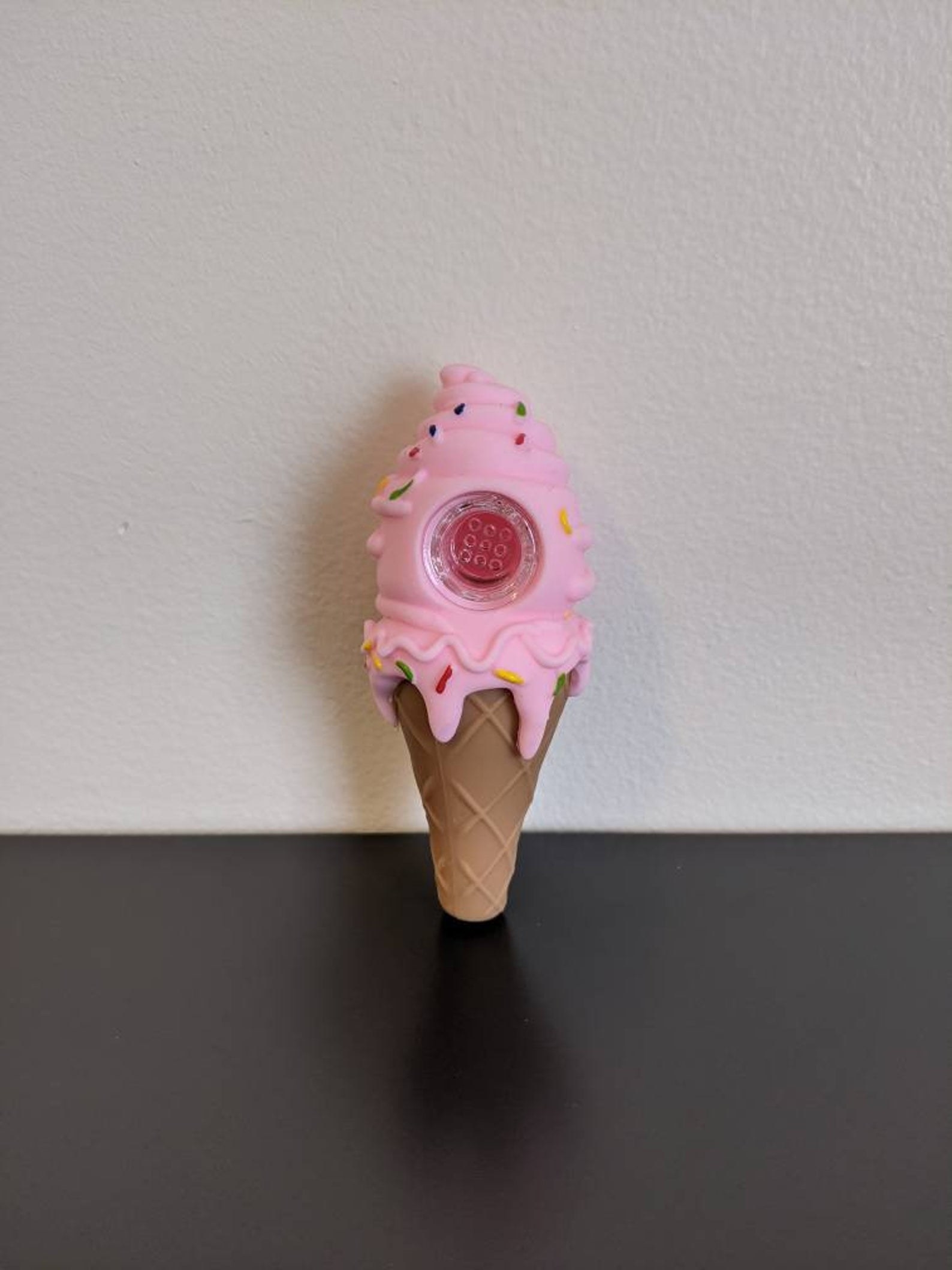 the ice cream cone-shaped pipe which has pink ice cream on top with colorful sprinkles