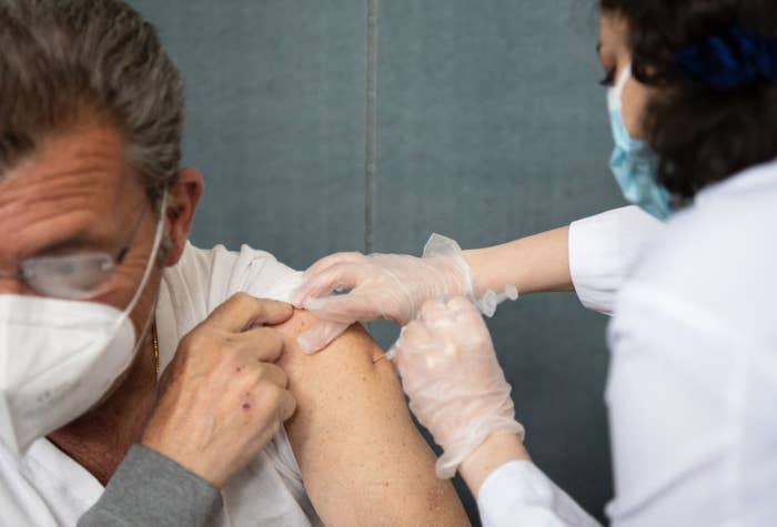 A man is injected with a coronavirus vaccine by a nurse