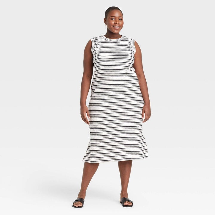 Model white dress with black stripes, goes past the knee