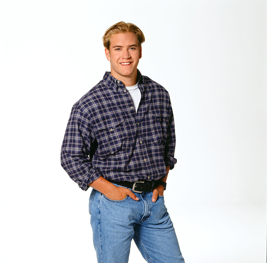 mark paul is in light jeans and plaid.