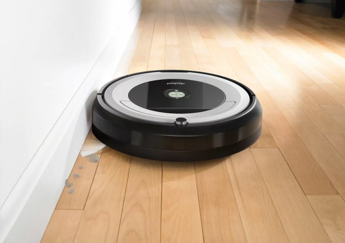 The iRobot Roomba in black and gray on a hardwood floor