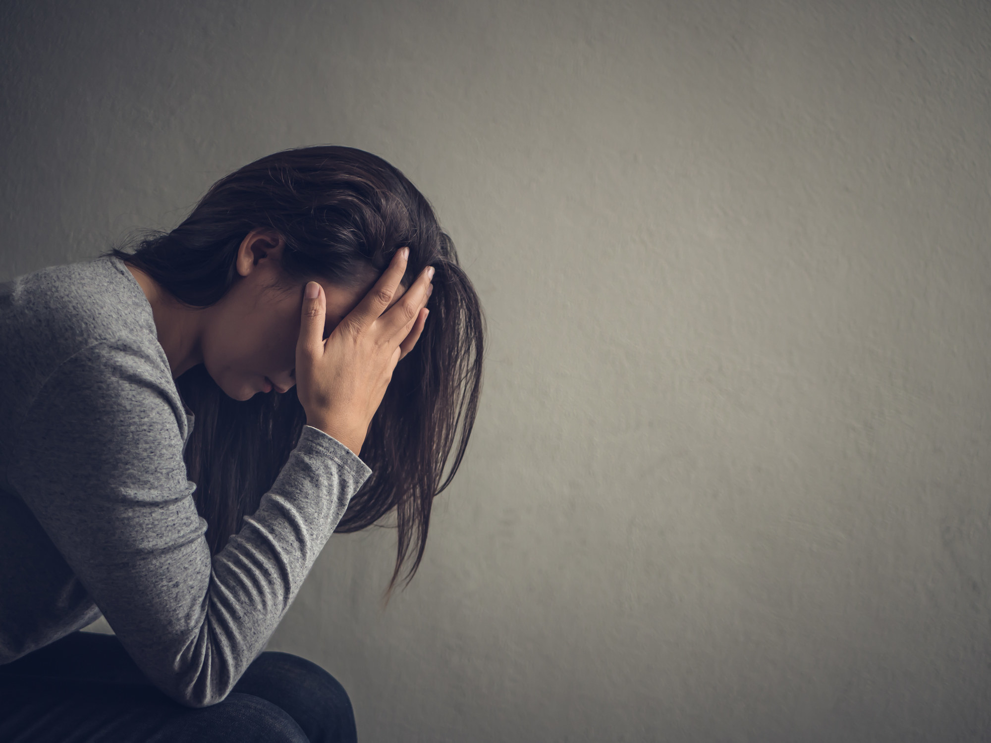 Upset woman sitting with her head in her hands