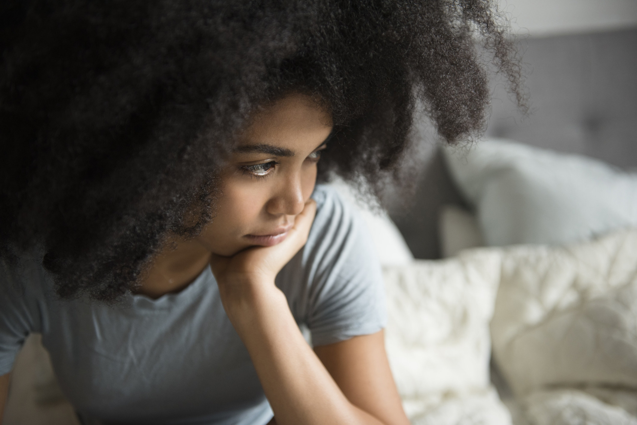 Pensive woman sitting with her head in her hands