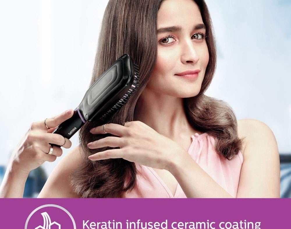 Alia Bhatt using the brush on her hair.
