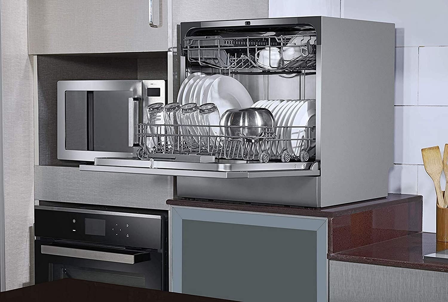 Dishwasher kept in the kitchen with utensils inside.