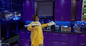 a gif of Patti Labelle carrying two wrapped presents 