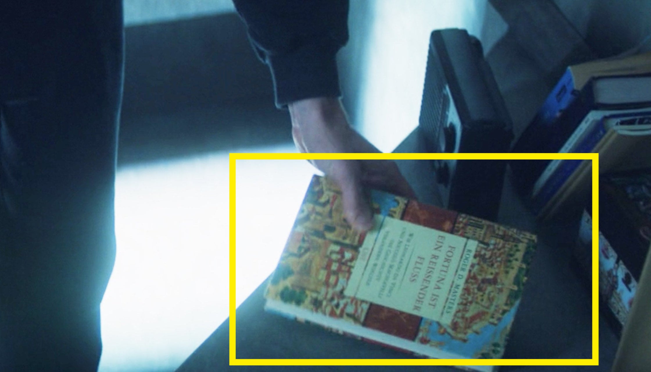 A close-up of Zemo holding his book