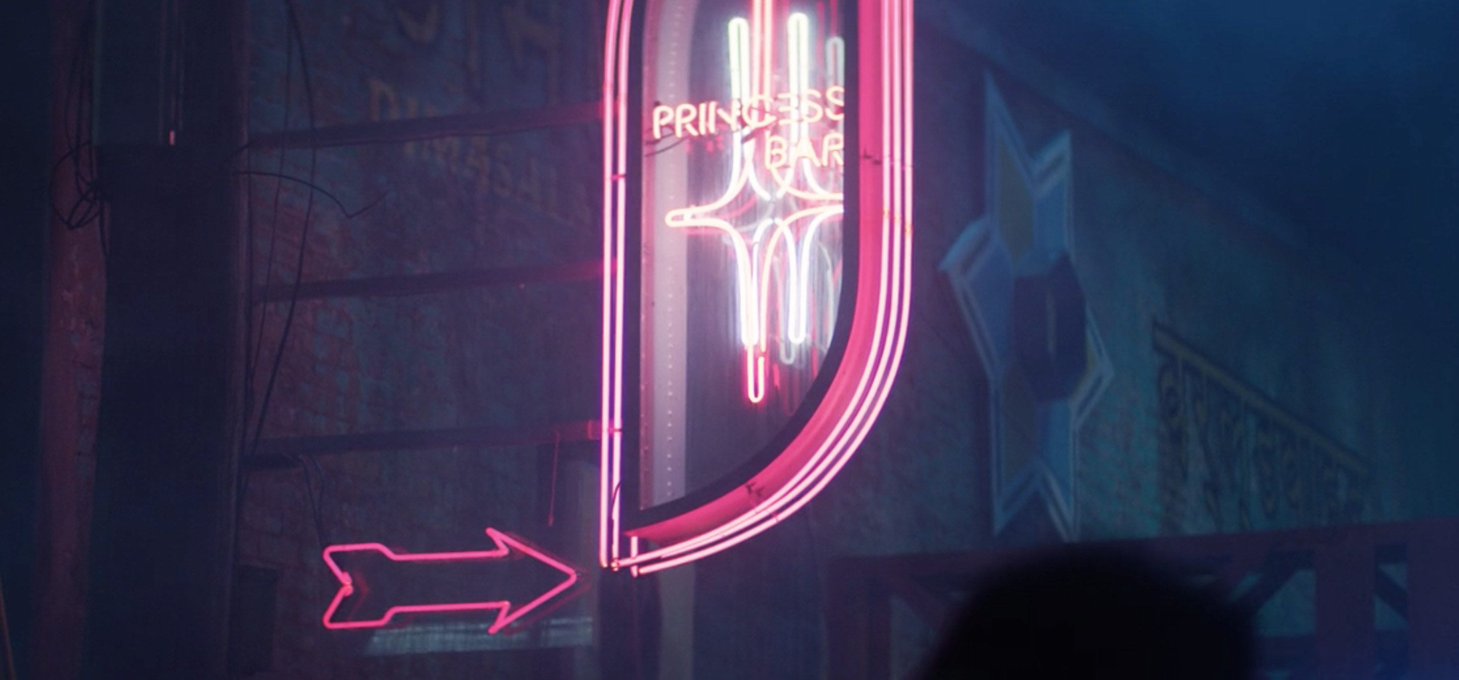 A close-up of a pink neon sign reading "Princess Bar"