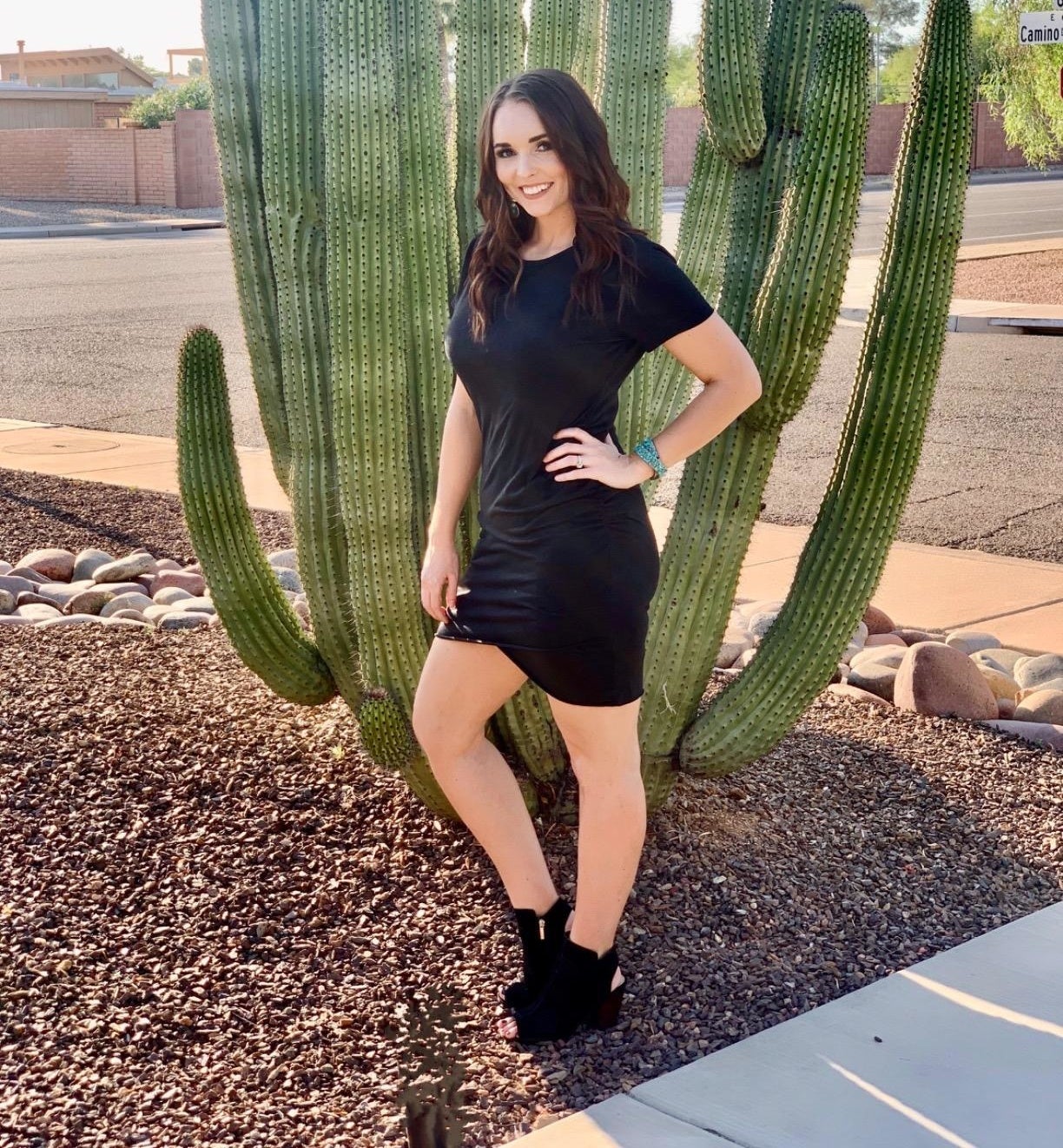 a reviewer wearing the dress in black in front of a cactus