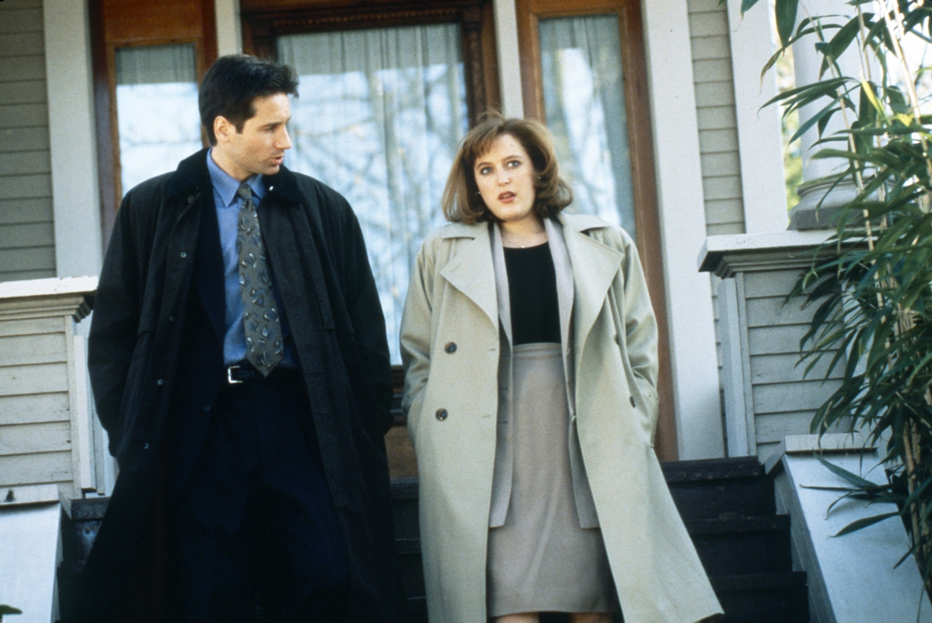 David Duchovny and Gillian Anderson walk down the stairs outside a house