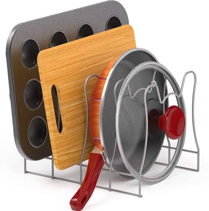 four slot wire rack with muffin pan, cutting board, skillet, and skillet lid stacked in their respective slots