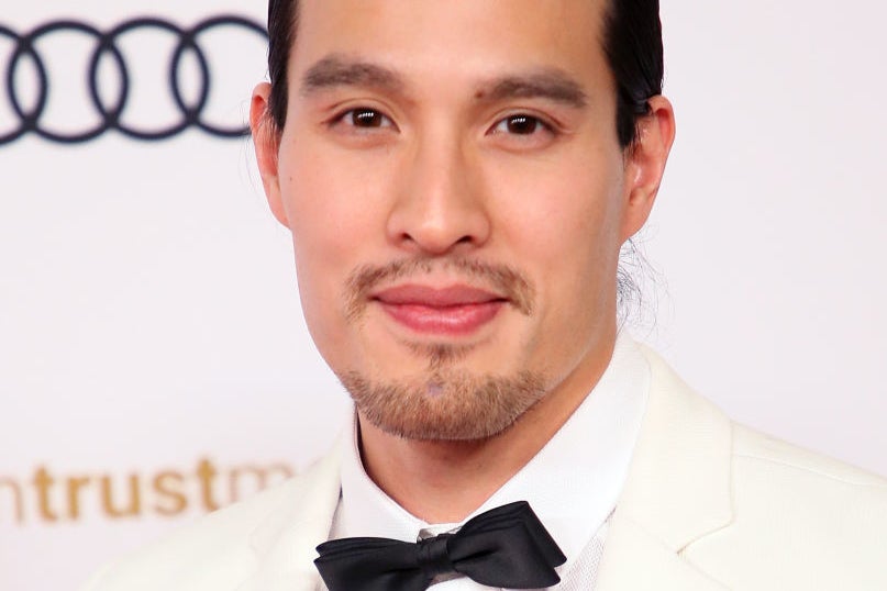 Desmond Chiam smiling while wearing a bright suit and bowtie