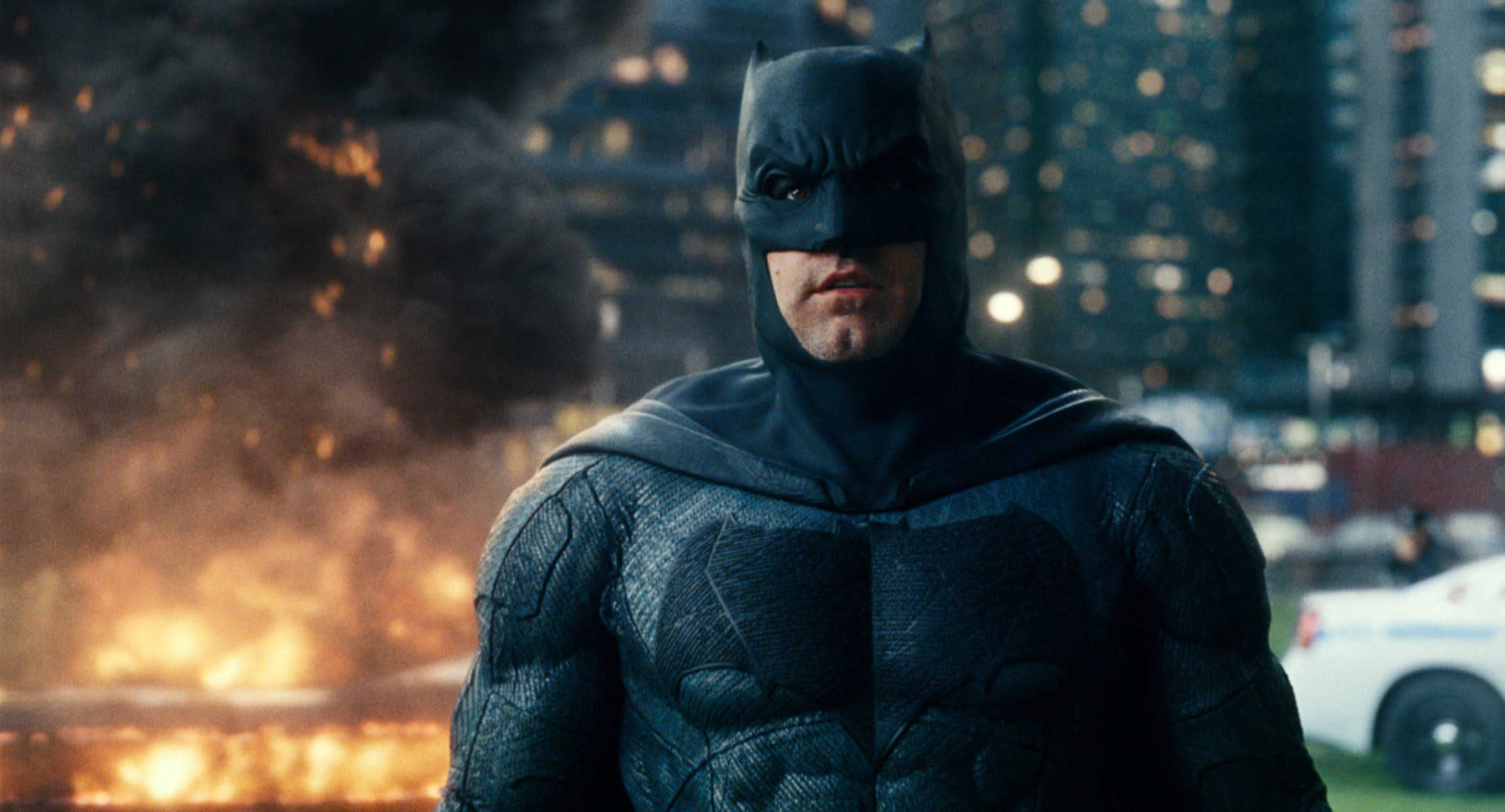 Photo of Ben Affleck dressed as Batman with an explosion behind him