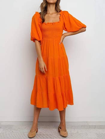 A model wearing the dress in orange