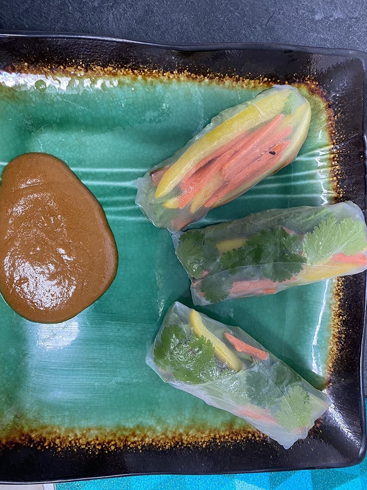Reviewer image of spring rolls made using the rice paper, raw veggies, teriyaki baked tofu, and a peanut dipping sauce