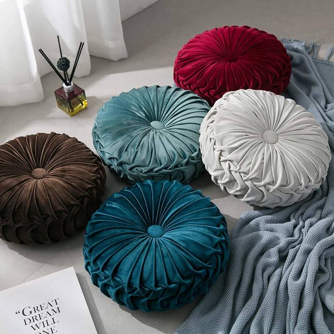 The round pillows in red, teal, white, blue, and brown