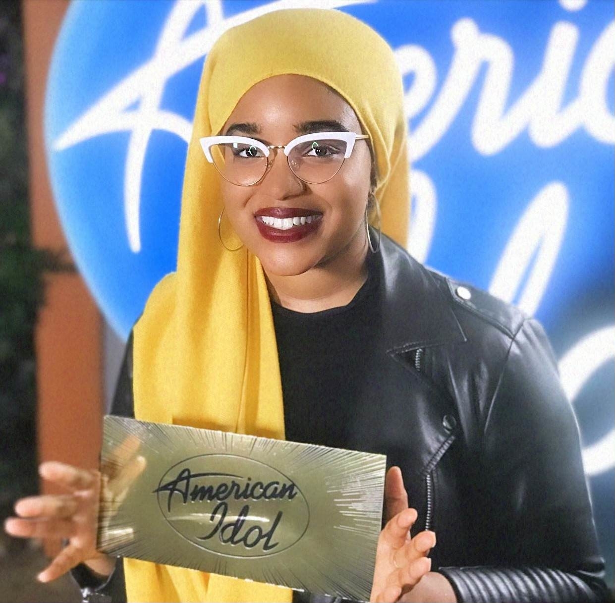 Amira holds up a golden ticket with the &quot;American Idol&quot; logo on it