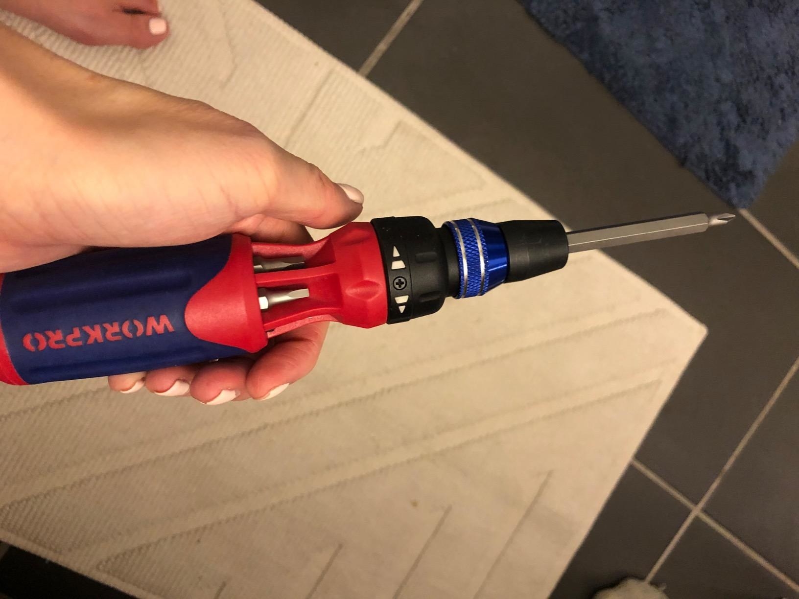 image of reviewer holding the workpro screwdriver which has bits in compartments within the handle