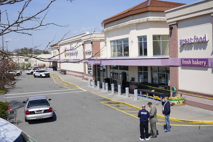 Police vehicles are parked in the lot outside a grocery store