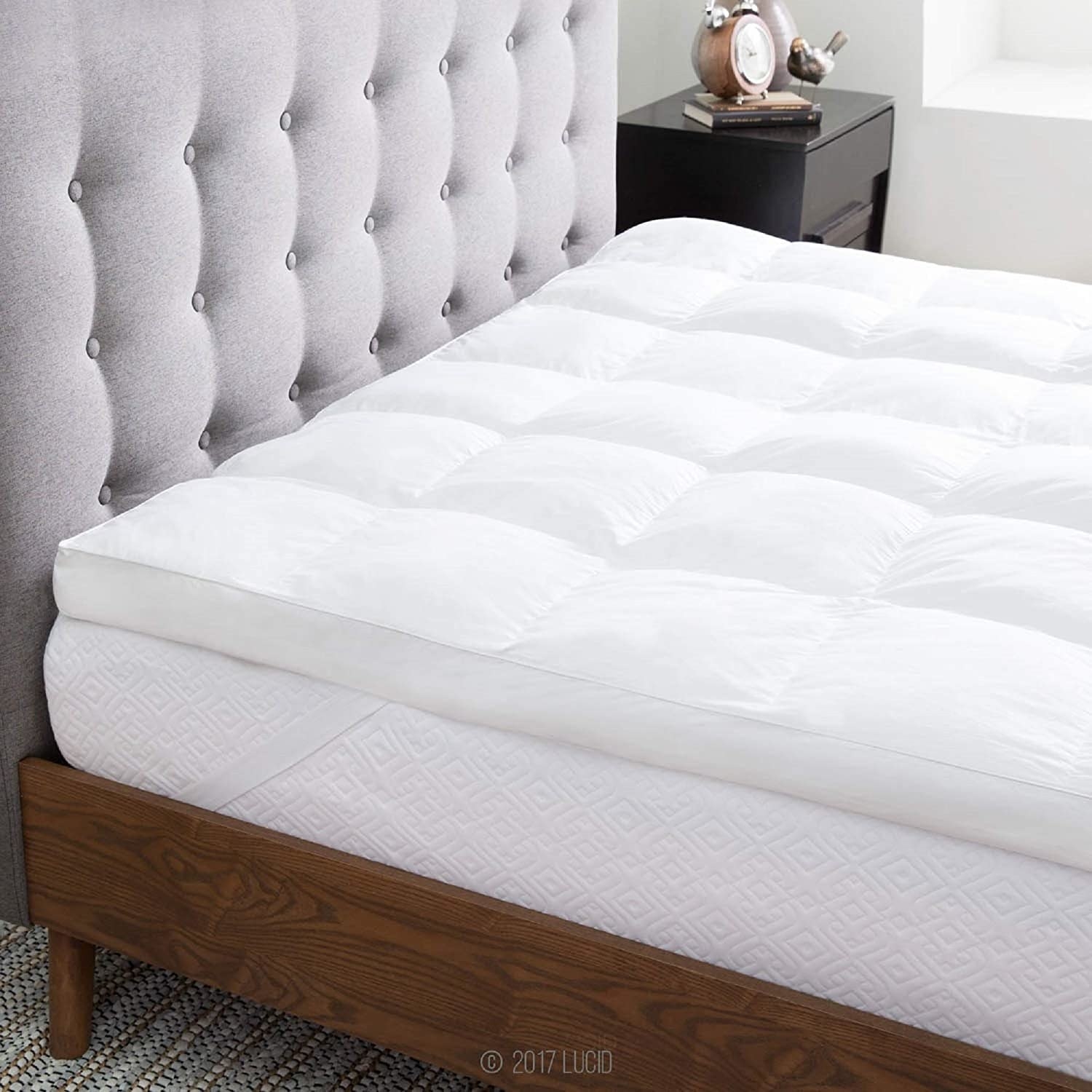 the down alternative mattress topper laid over a bed