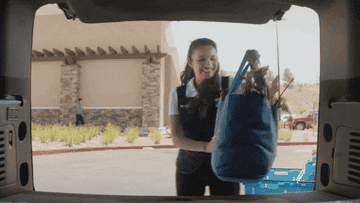 Walmart associates bringing bag of groceries to customer&#x27;s trunk