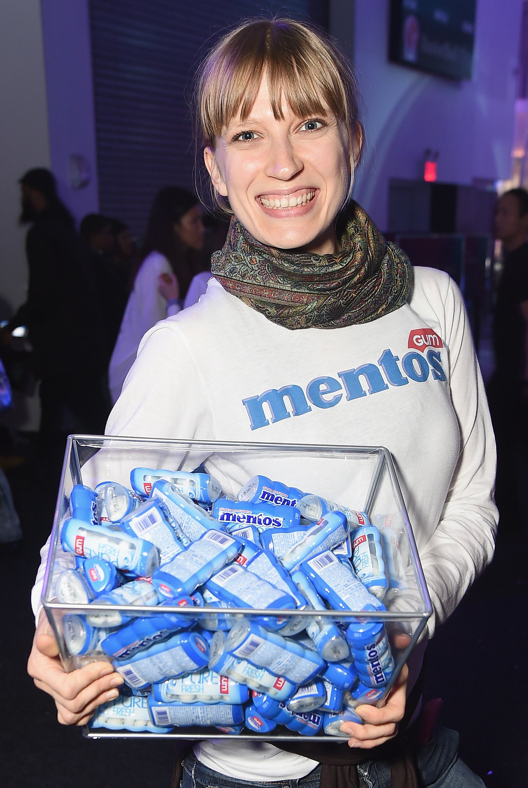 A woman holds a bin of Mentos