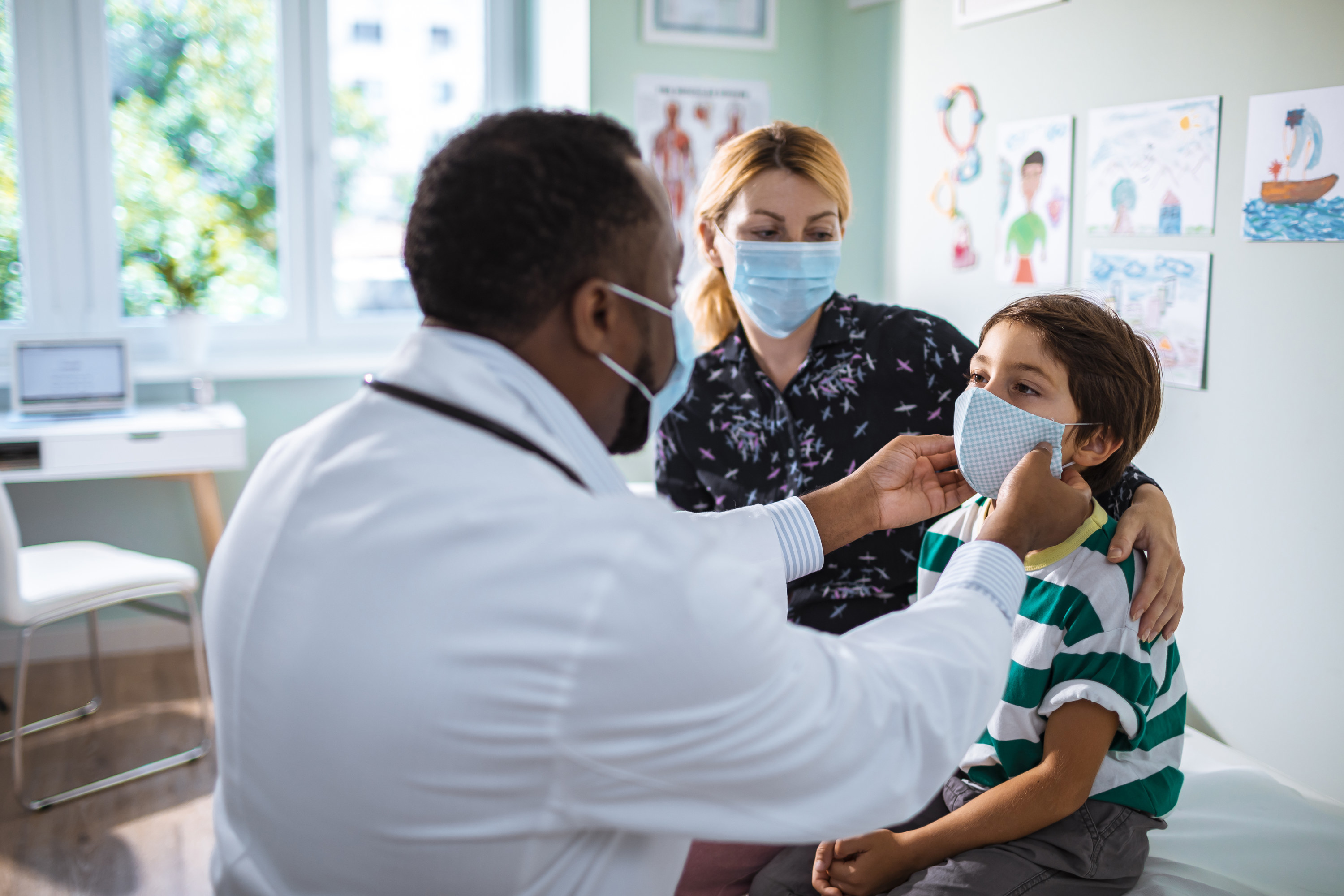 Pediatrician examining a young boy during a visit