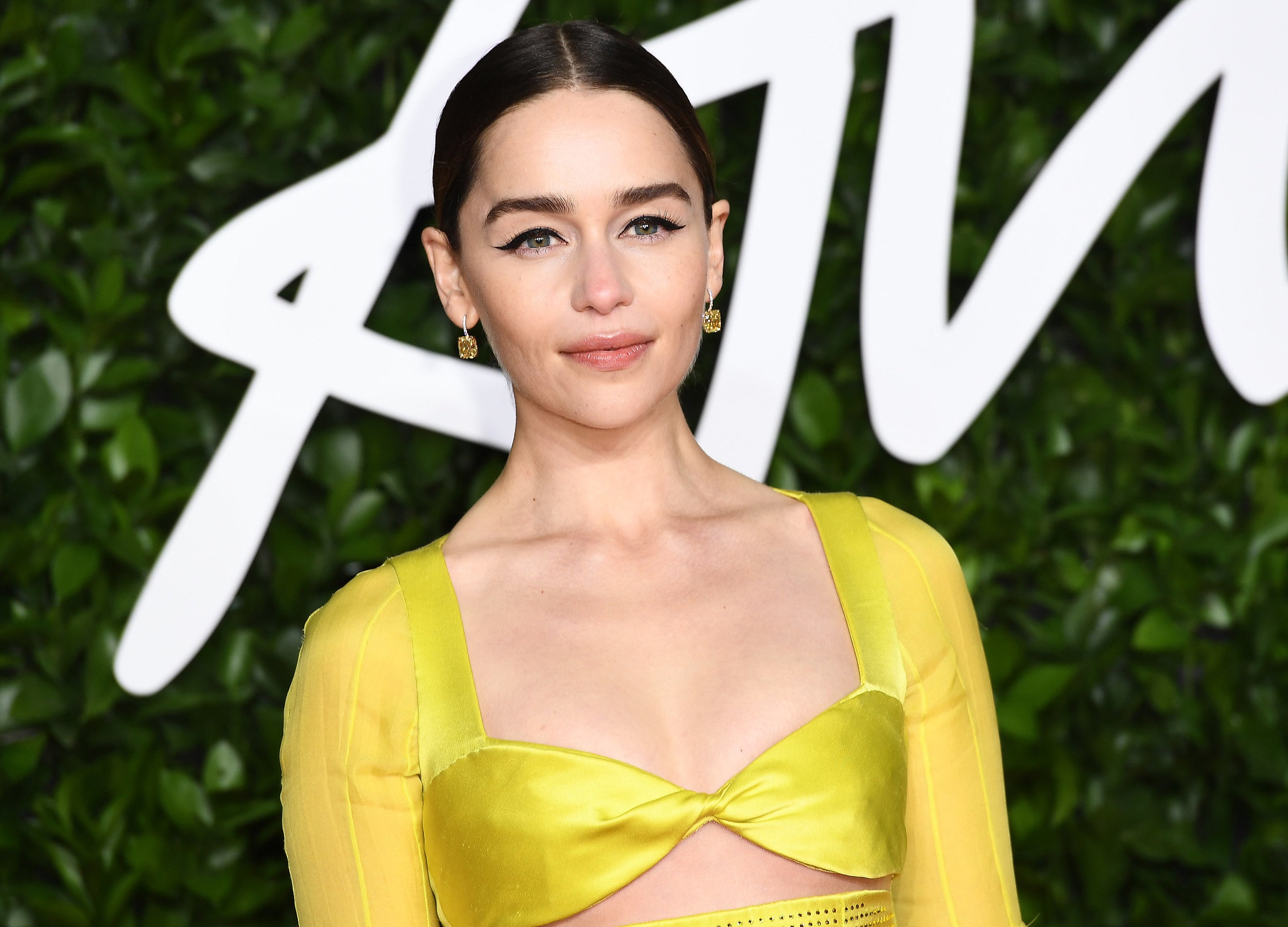 Emilia Clarke wears a bright yellow dress to an event