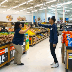 Two Walmart Associates jumping up to high-five