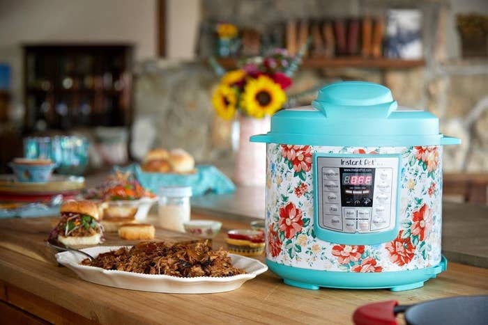 The Instant Pot, which has push-button settings, a floral print, and blue plastic top