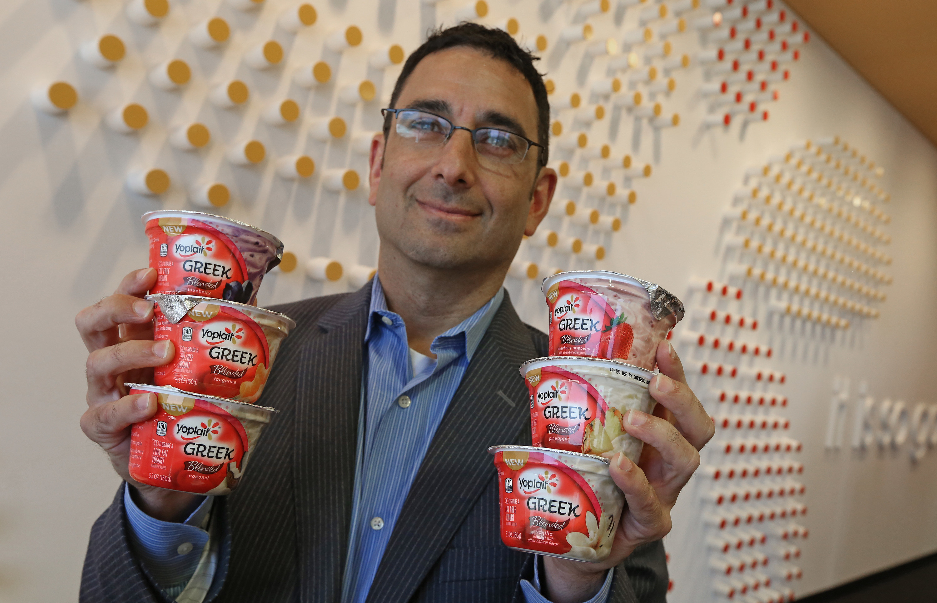 Man holding containers of Yoplait Greek yogurt