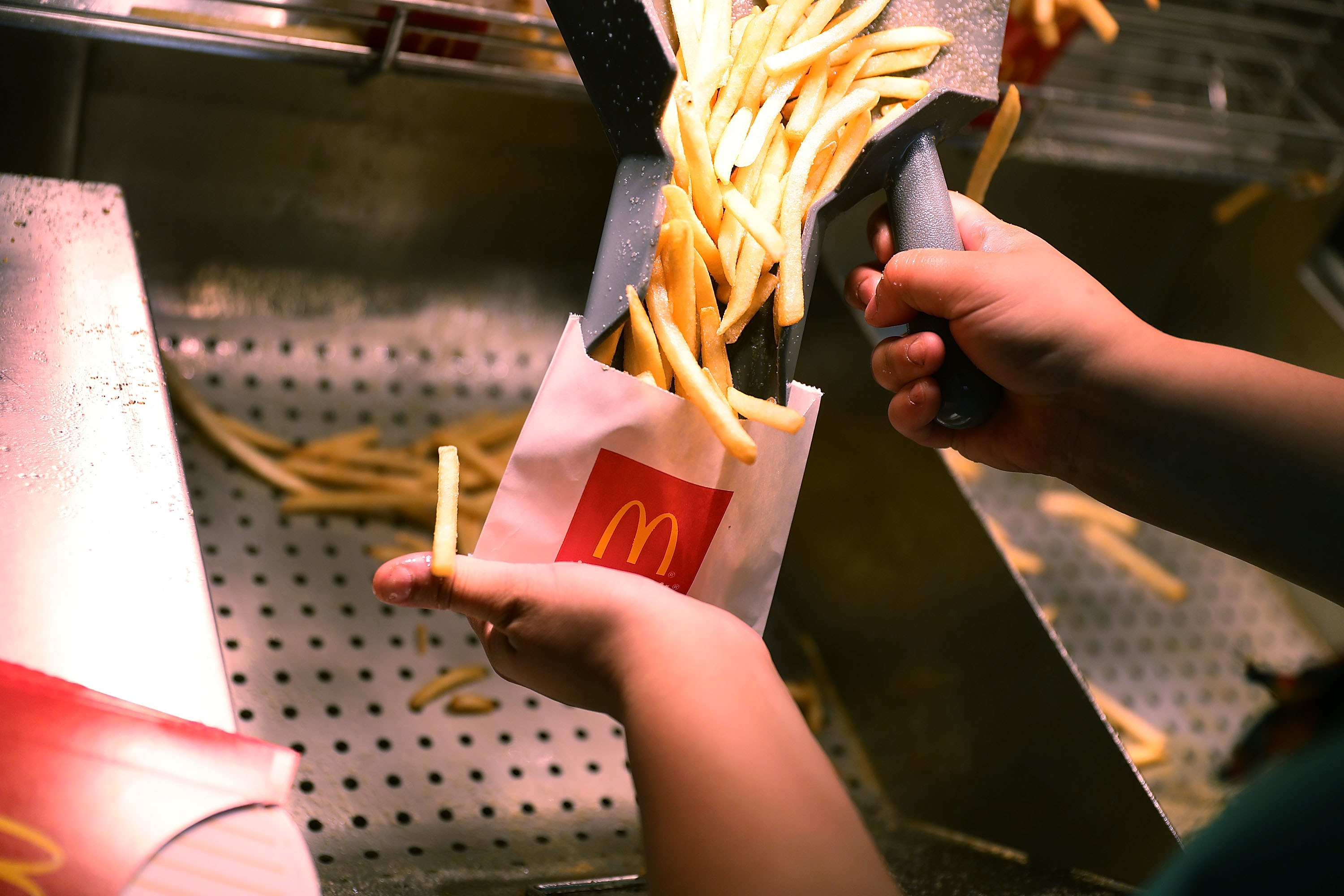 Person putting fries into a McDonald&#x27;s packet