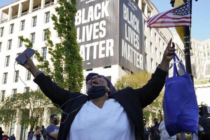 Robinson raises her arms and cheers, a "Black Lives Matter" banner on the building behind her