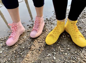two reviewers wearing high-top sneaker style rain shoes in light blue and yellow