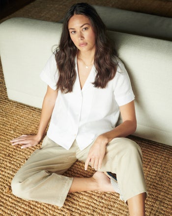 a model wearing the linen pants in khaki with a white button up shirt