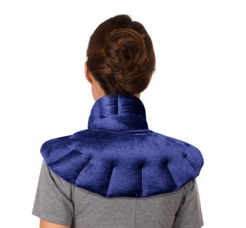 Model with a blue contoured heat pack wrapped around the back of their neck fanned out over their shoulders